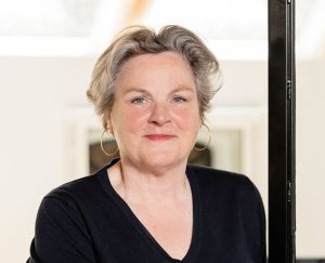 Professional woman in a black shirt smiling.